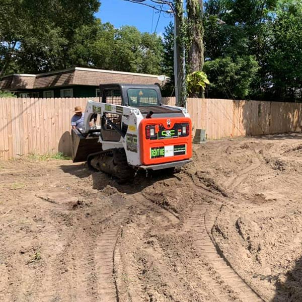 Bobcat on a worksite ontop of dirt with tire tracks