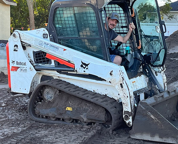 Matt Fernald, the owner of MJF Grading, sitting in a Bobcat